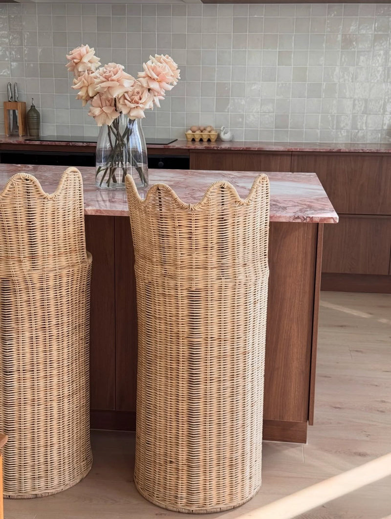 Two custom handcrafted natural rattan bar stools with a sculptural curved backrest, designed for luxury kitchen islands and contemporary interiors. Designed y HC Homewares.