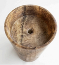 A round stone pedestal basin with a natural marble-like texture in earthy brown, beige, and gray tones.