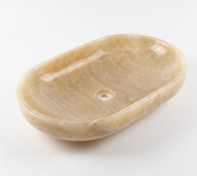 An oval stone bathroom basin in a warm beige marble, crafted with onyx stone.