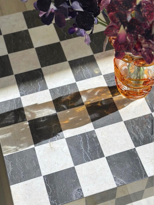 A close-up of a HC Homewares black and white checkered coffee table, showcasing all its unique features.