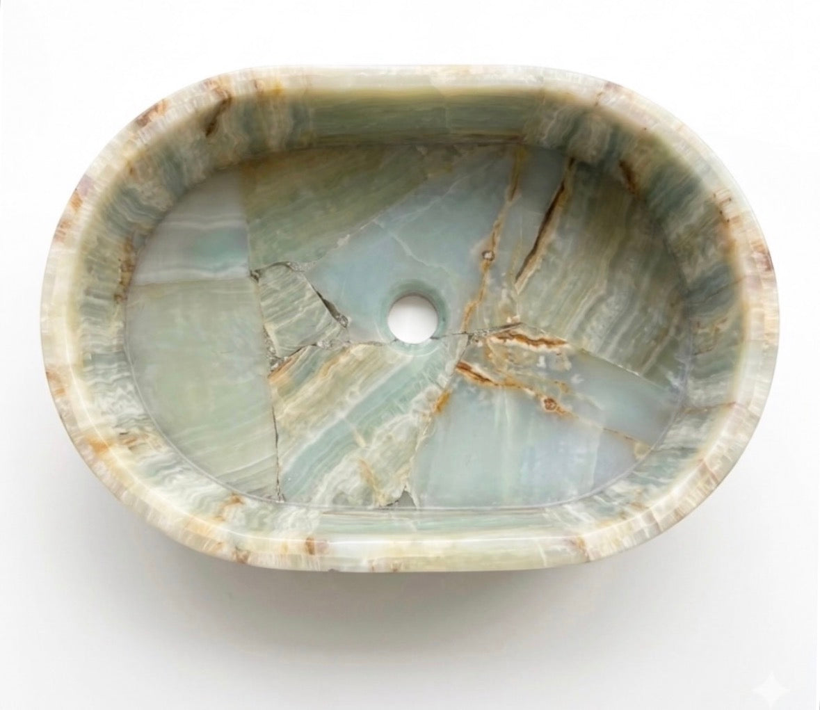 An high-end oval stone basin with a natural onyx texture in pale green, beige, and gray tones, featuring a central drain hole and polished edges.