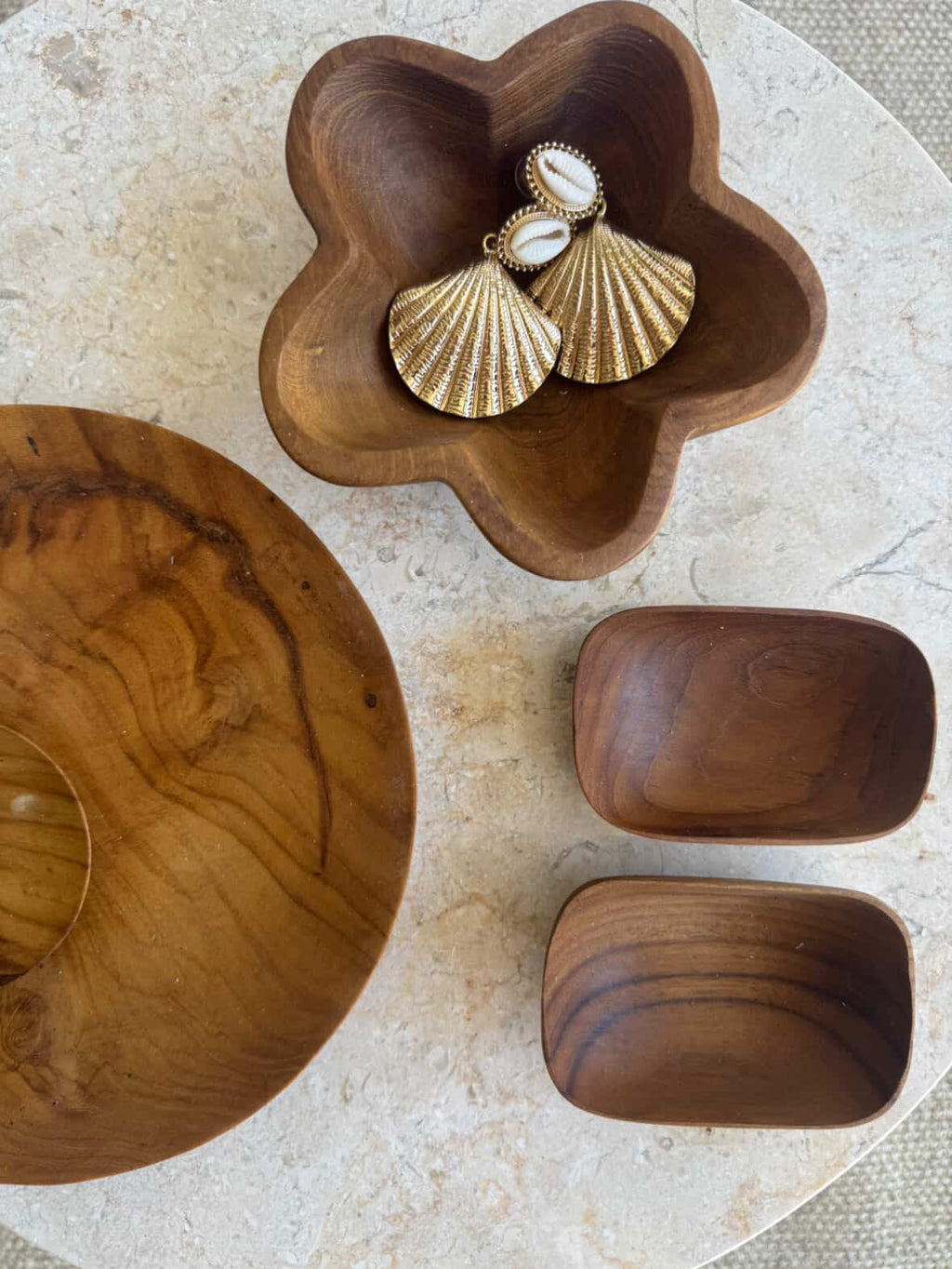 A set of handcrafted wooden serving dishes, including a large oval bowl, a flower-shaped bowl and two smaller rectangular bowls, showcasing HC Homewares luxury collection.